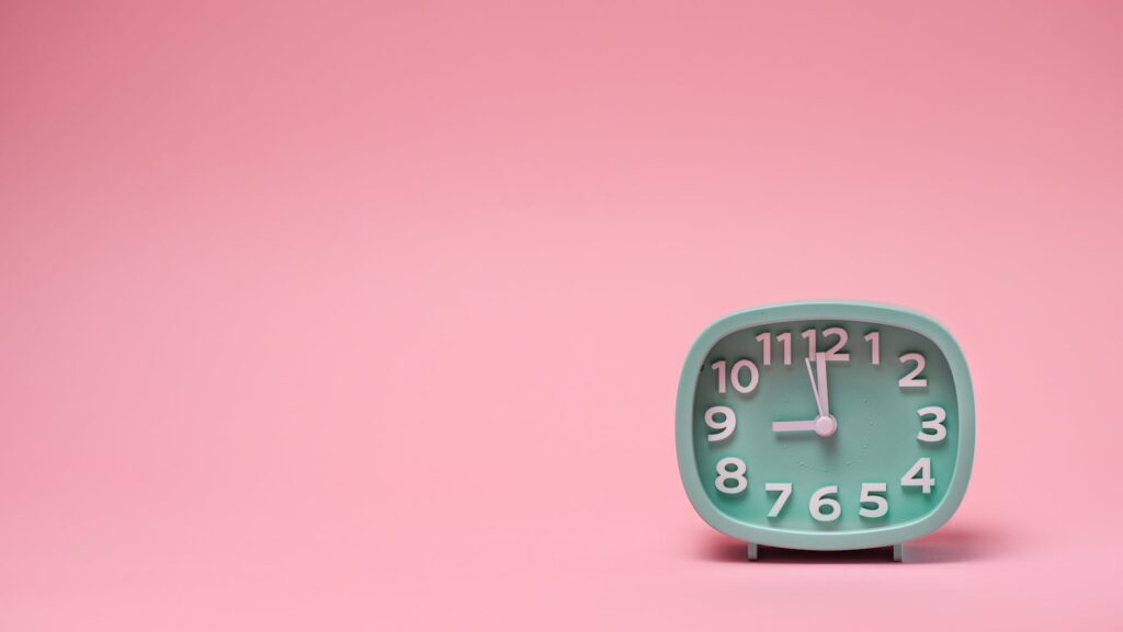 a clock on a pink background